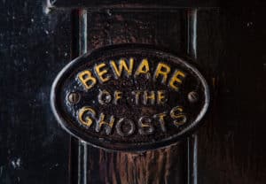 a plaque saying beware of the ghosts in the article buying a haunted house