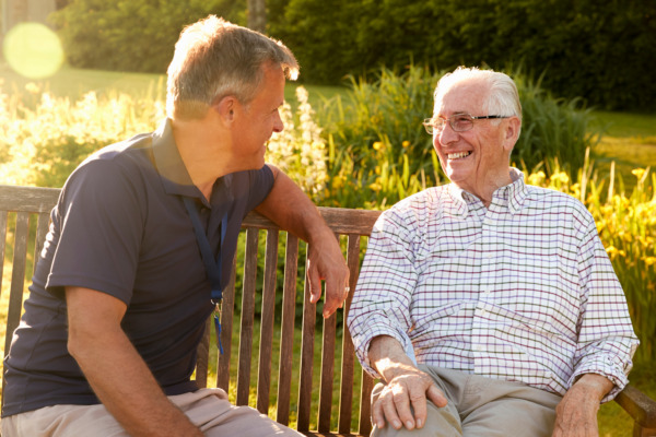 Planning for long-term care. This is a photo of a man visiting a senior in a residential home who has planned their long-term care and appointed a power of attorney
