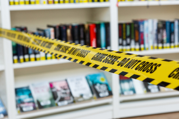 a crime scene in front of books from the article Wills and Estates - Can a murderer inherit from his/her victim?