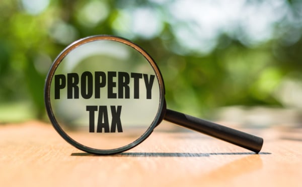 Photo of a magnifying glass with the words Property Tax in the lens as we examine the Additional Dwelling Supplement