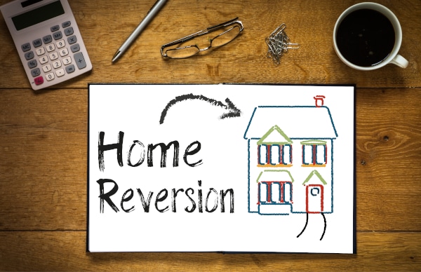 Image of a notepad with the words home reversion written on it with a drawing of a house indicating one of the options between home reversion plan or lifetime mortgage