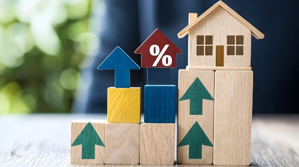 Wooden blocks with a model wooden house sitting on top with green arrows pointing up and a percentage sign indicating Zoopla House Price Index