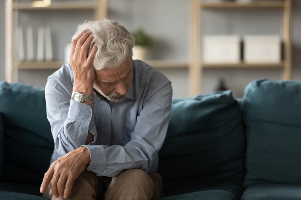 A confised man sitting on a couch indicates why it's important to plan for the future with a Power of Attorney and dementia