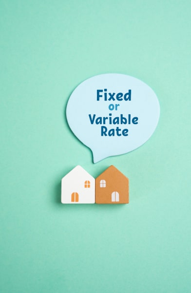 Two model houses on a green backtround wiht a callout saying Fixed or Variable Rate when considerning a mortgage