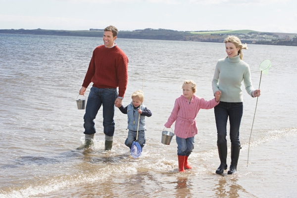 Family walking along a beach in the autumn and discussing how to look out for your childen with a Will